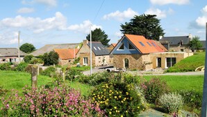 A rural village with stone houses, a grassy field, and flowering plants. - L'Hirondelle by Interhome (Saint Jean du Doigt)