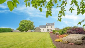A large, well-maintained lawn with a stone pathway leading to a house with a sloped roof and multiple windows. - L'Oasis by Interhome (Plouneour Trez)