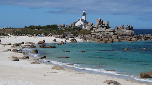 A coastal scene with a lighthouse, rocky outcrops, and a sandy beach. - L'Oasis by Interhome (Plouneour Trez)