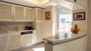 Una cocina moderna con armarios empotrados, una encimera con frutero y una ventana que proporciona luz natural.