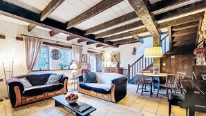 A cozy living room with two sofas, a coffee table, and a dining area with a table and chairs. - Dolce Vita by Interhome (Plouha)