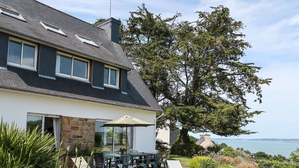 A two-story house with a patio area featuring outdoor furniture and a view of the sea. - Ker Svea by Interhome (Plestin les Greves)