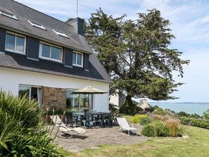 A two-story house with a patio area featuring outdoor furniture and a view of the sea. - Ker Svea by Interhome (Plestin les Greves)