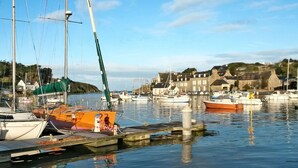 A marina with boats docked, calm water, and buildings in the background. - Valhalla, chez Jules by Interhome (Planguenoual)