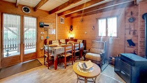 A cozy cabin interior with a dining area, a seating area, and a fireplace. - Lovely home in Le Ménil (Le Ménil)