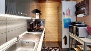 A compact kitchen with a stainless steel sink, a gas stove, a microwave, and a refrigerator. - Lovely home in Le Ménil (Le Ménil)
