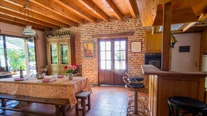A rustic kitchen with wooden beams, a brick wall, and a tiled floor. - Alexandre by Interhome (La Chapelle-Saint-Sauveur)