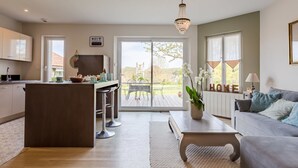Un espace de vie moderne comprenant une cuisine, un coin repas et un salon confortable.