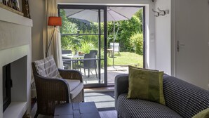 Una sala acogedora con chimenea, un sofá y un comedor con mobiliario de exterior.