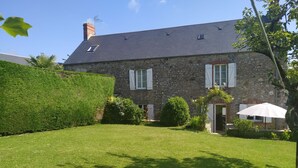 A stone house with a sloped roof, white shutters, and a well-maintained lawn. - La Bonneraie by Interhome (St.Maurice-en-Cotentin)