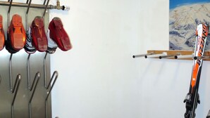 A ski storage area with a rack holding skis and ski boots. - Apartment Huber by Interhome (Zell am Ziller)