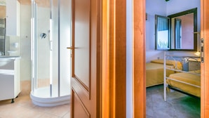 A bathroom with a shower, toilet, and sink.