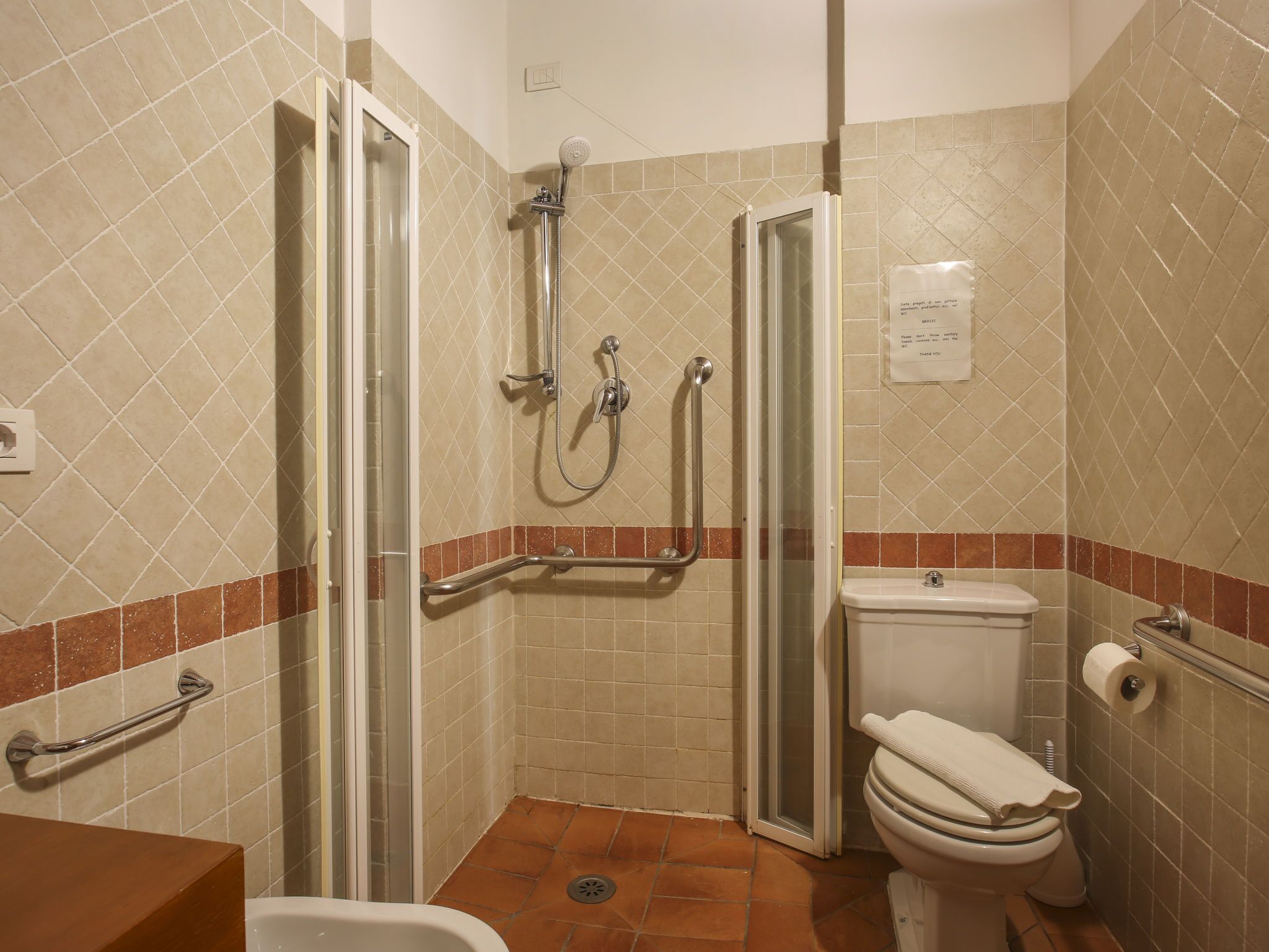 A bathroom with a shower, toilet, and sink.
