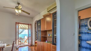 A spacious room with a wooden floor, a ceiling fan, and a view of the ocean through an open door. - Baroccia da Mary by Interhome (Rio Marina)