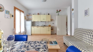 Ein kompakter Wohnbereich mit einer Küche, einem Essbereich und einem Sofa.