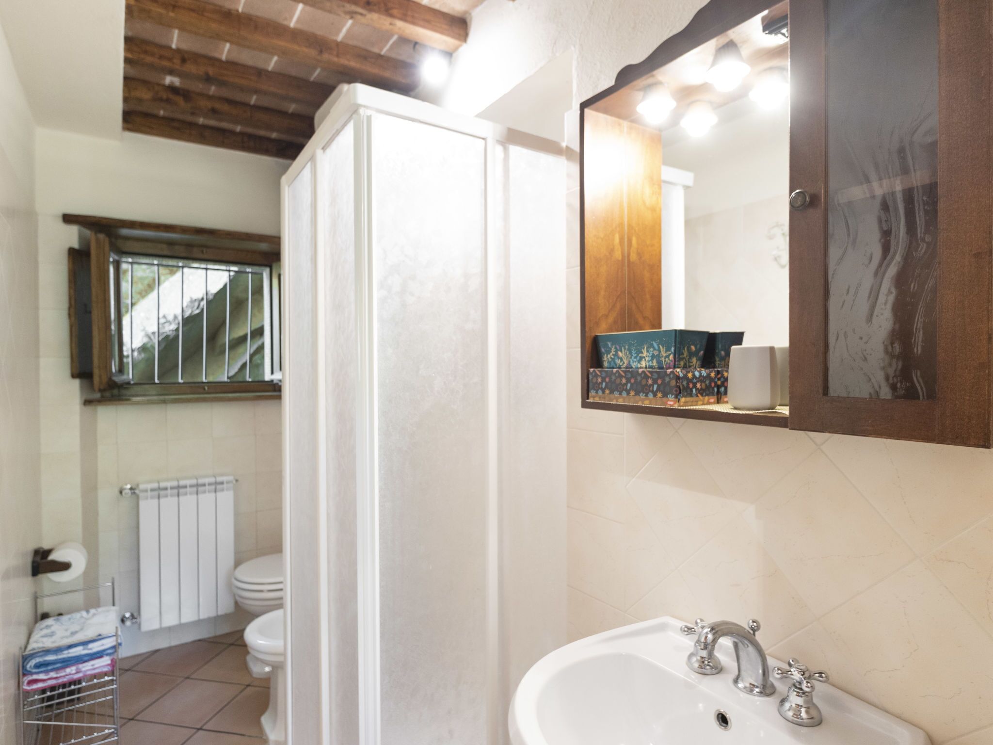 Une salle de bain avec un lavabo blanc, un miroir et un espace douche.