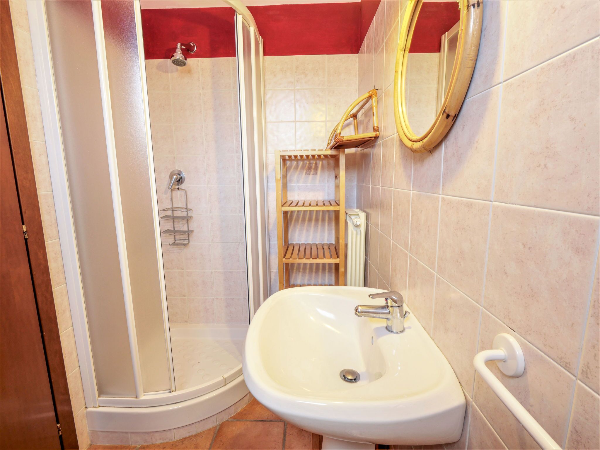 A bathroom with a shower, a sink, and a mirror.