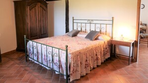 A bedroom with a bed, wooden wardrobe, and a nightstand. - Rosa - Borgo la Civitella by Interhome (Roccastrada)