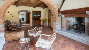 An open-plan living area with a kitchen, dining table, and seating area. - Santa Lucia by Interhome (Castiglion Fiorentino)