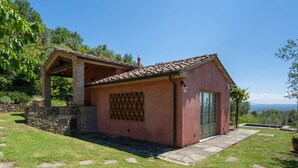Una pequeña casa rústica con techo de tejas, base de piedra y puerta verde.