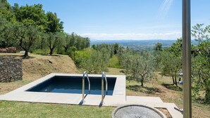 Una piscina con vista a un paisaje montañoso y montañas al fondo.
