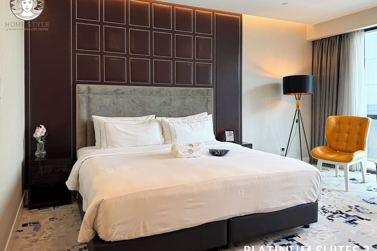 Ein Hotelzimmer mit einem großen Bett, einem modernen Kopfteil mit LED-Beleuchtung, einer Stehlampe und Blick auf die Stadt.