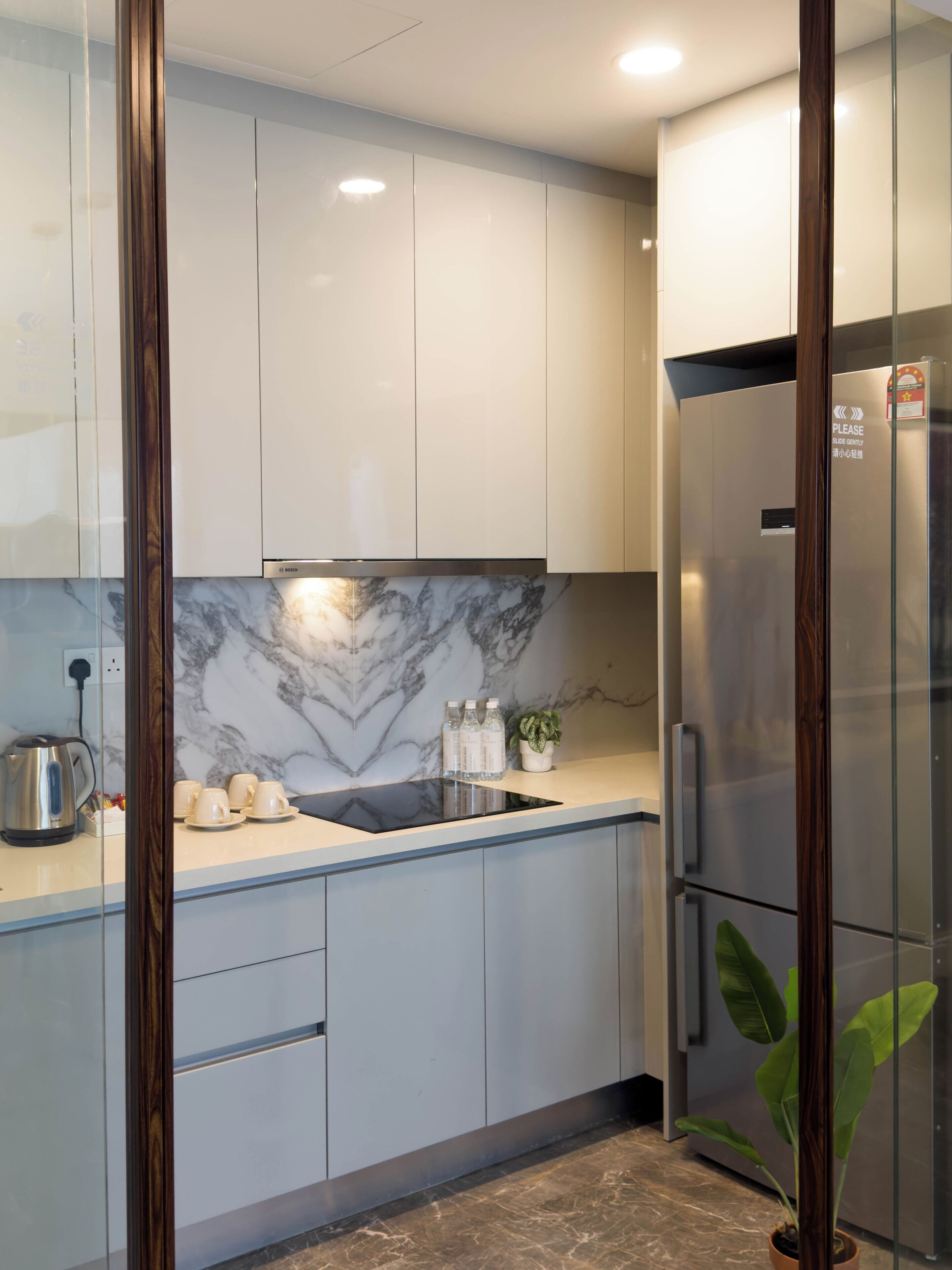 A modern kitchen with a marble backsplash, stainless steel appliances, and a minimalist design.