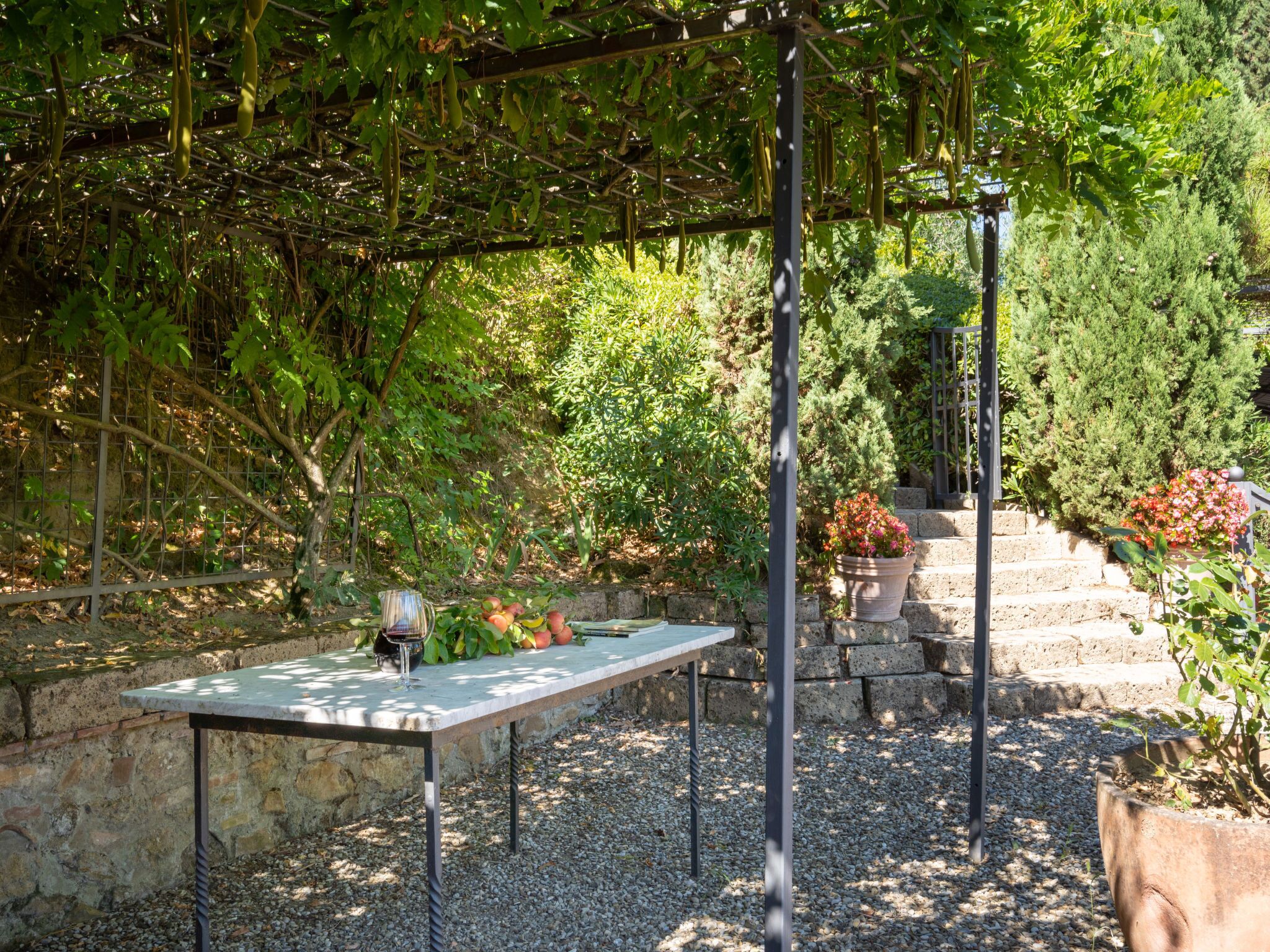 A garden patio with a table, a wine glass, and a potted plant.
