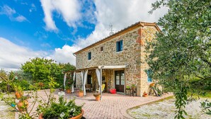 A stone building with a covered patio, potted plants, and a barrel. - La Casina by Interhome (Vinci)