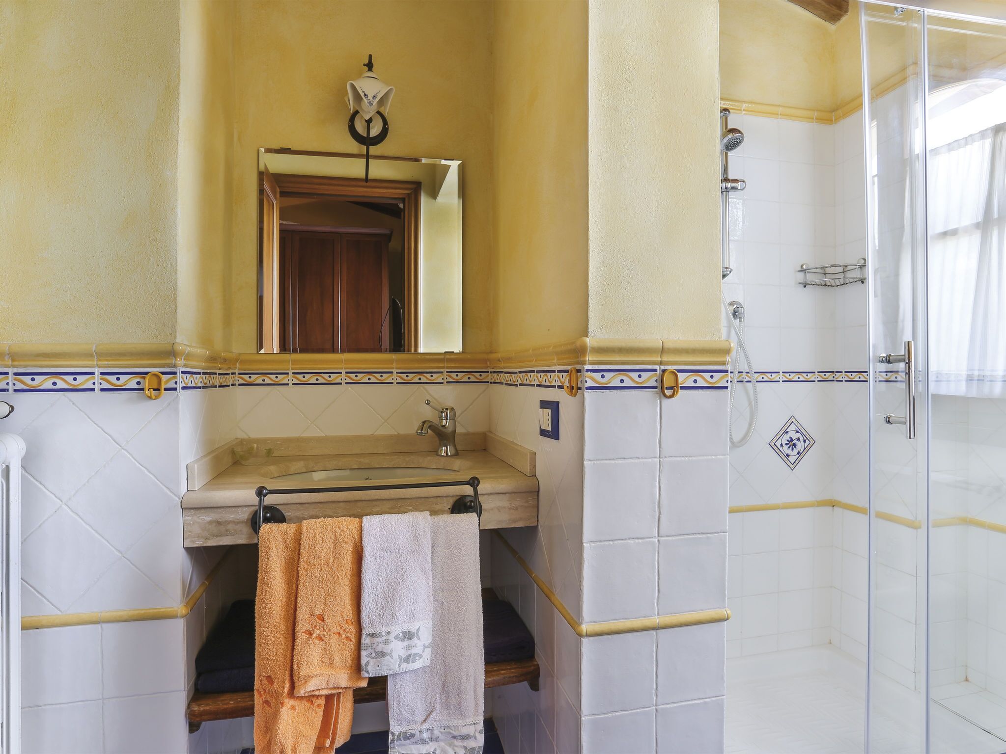 Une salle de bain avec un lavabo, un miroir et une douche.