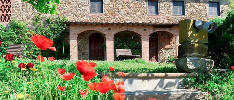 A stone building with a rustic appearance, featuring a central doorway and multiple windows.