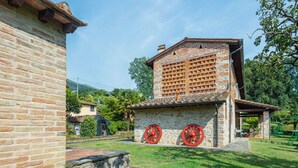 Un bâtiment traditionnel en briques, doté d’un toit en tuiles et d’un petit porche.