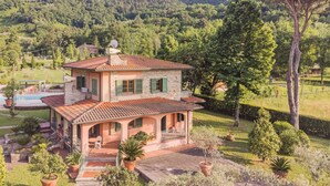 A two-story stone house with a tiled roof, a swimming pool, and a garden with potted plants. - Costacce by Interhome (Camaiore)