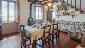 A dining area with a wooden table, chairs, and a patterned sofa. - Paradiso by Interhome (Camaiore)