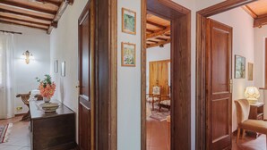 A traditional interior with wooden doors, a dining area with a table and chairs, and a hallway leading to another room.