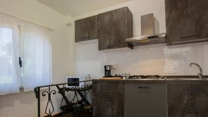 A compact kitchen with a gas stove, microwave, and a coffee maker. - Vacation home Teresa by Interhome (Lucca)