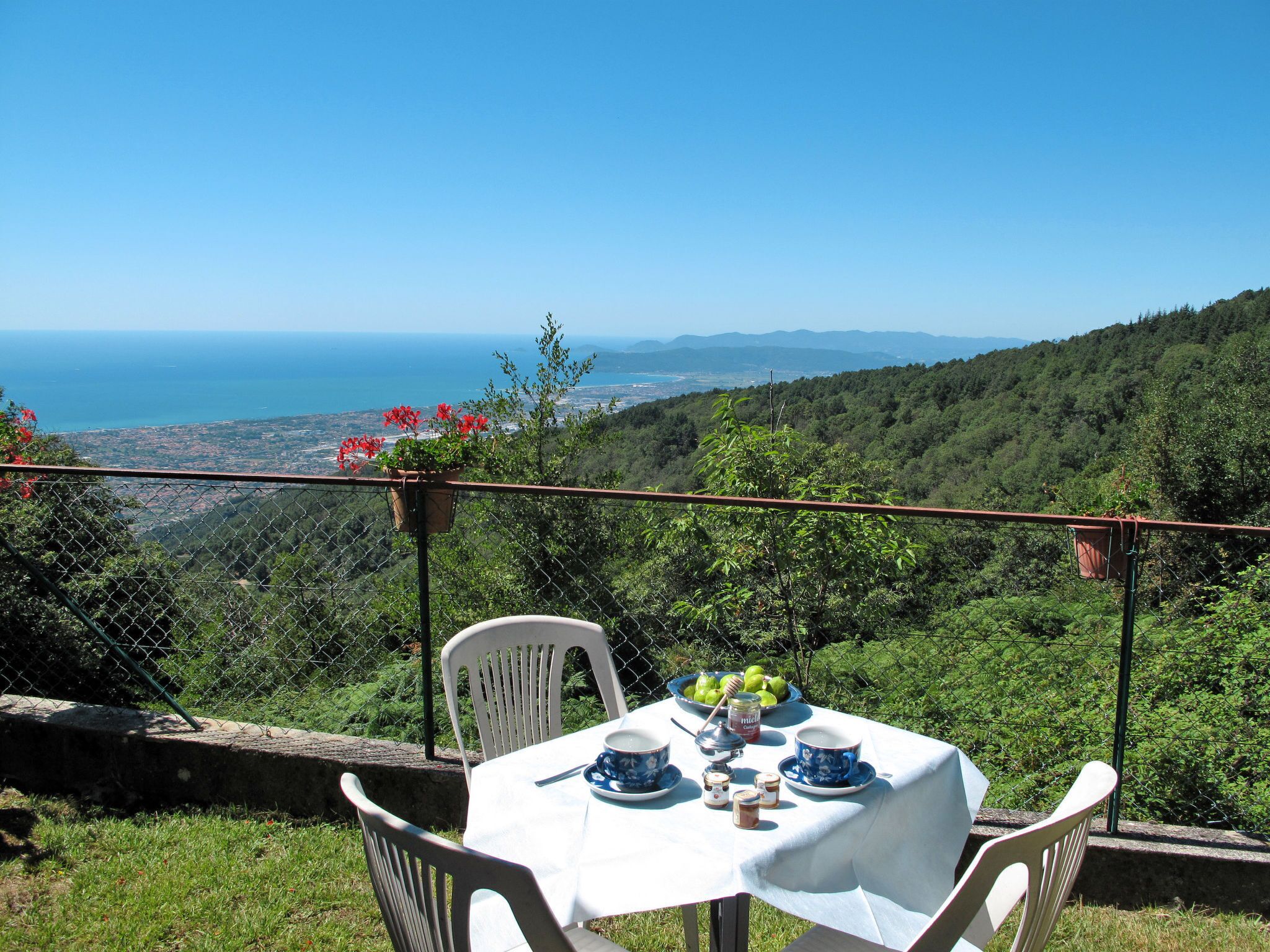 Une table dressée à l’extérieur, offrant une vue magnifique sur la mer et les collines.