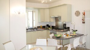 Una cocina moderna con armarios blancos, una isla central con sillas, una estufa y un fregadero.
