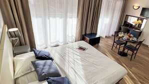A hotel room with a bed, a desk, and a chair.