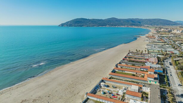 A coastal town with a beach, buildings, and a mountain in the background. - Vacation home Colli by Interhome (Marina di Massa)
