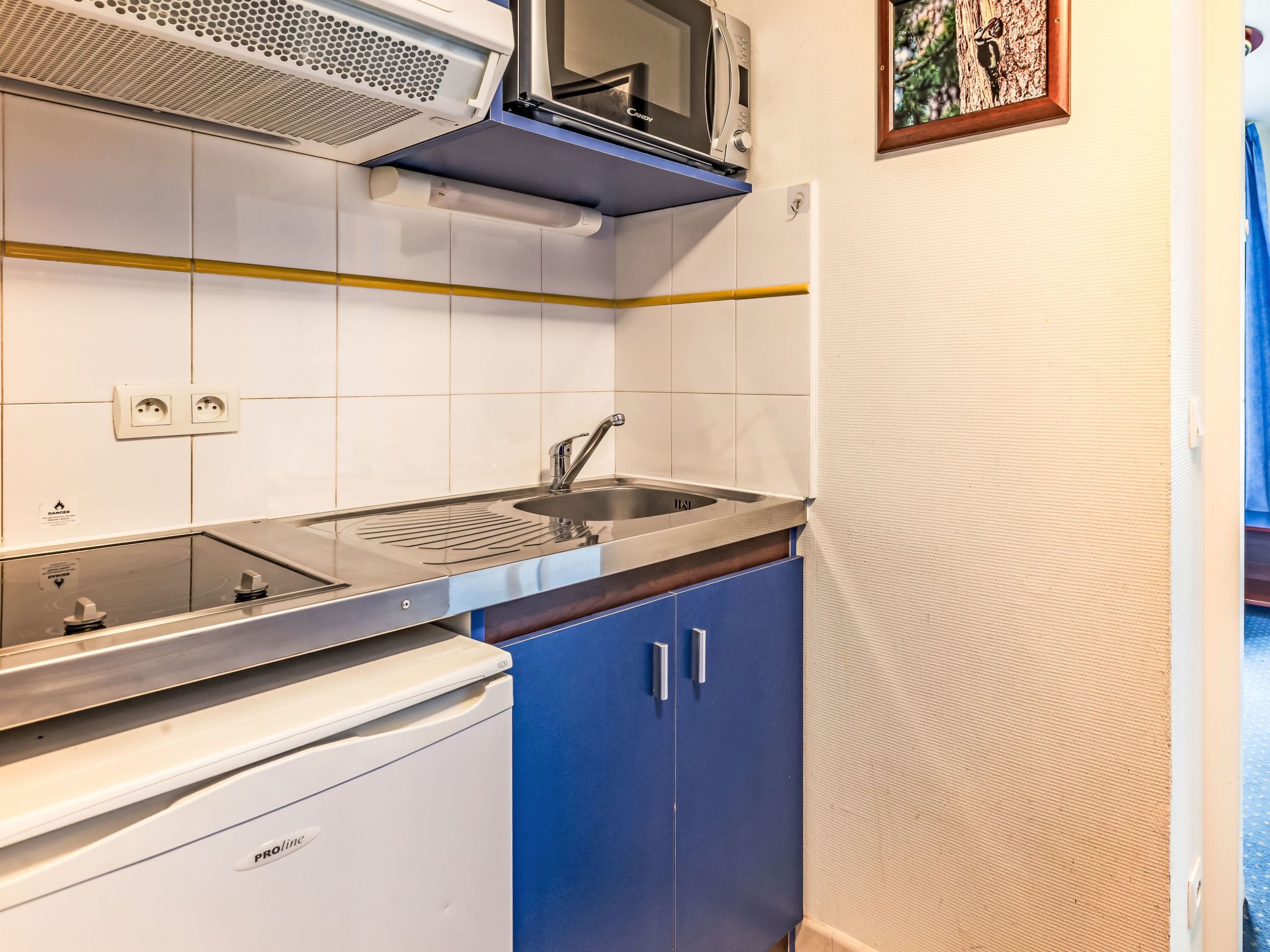 A compact kitchen with a microwave, sink, and dishwasher.