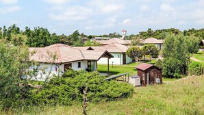 A cluster of white buildings with red-tiled roofs, surrounded by greenery and a clear sky. - Rosolina Mare Club by Interhome (Rosolina Mare)