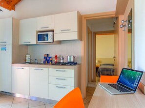 Kjøleskap, mikrobølgeovn, kjøkkenutstyr og spisebord