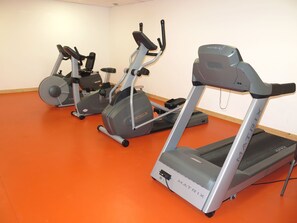 A gym with treadmills and elliptical machines.