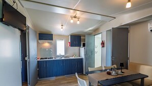 Une cuisine compacte avec un coin repas, un plancher en bois et un design moderne.