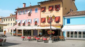A gelateria with outdoor seating and a blue building across the street. - Albatros by Interhome (Caorle)