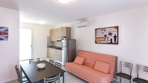 A compact living space with a kitchenette, dining area, and a sofa.