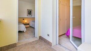 Un dormitorio con cama, mesita de noche, lámpara y armario.