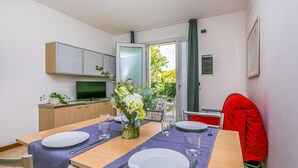A modern kitchen with a dining area set for two. - Robinia/Pinetine by Interhome (Caorle)