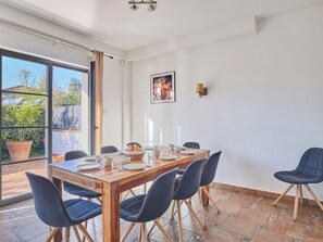 A dining area with a wooden table set for six, surrounded by six chairs. - Villas Odalys Collection Orée de Milady by Interhome (Biarritz)